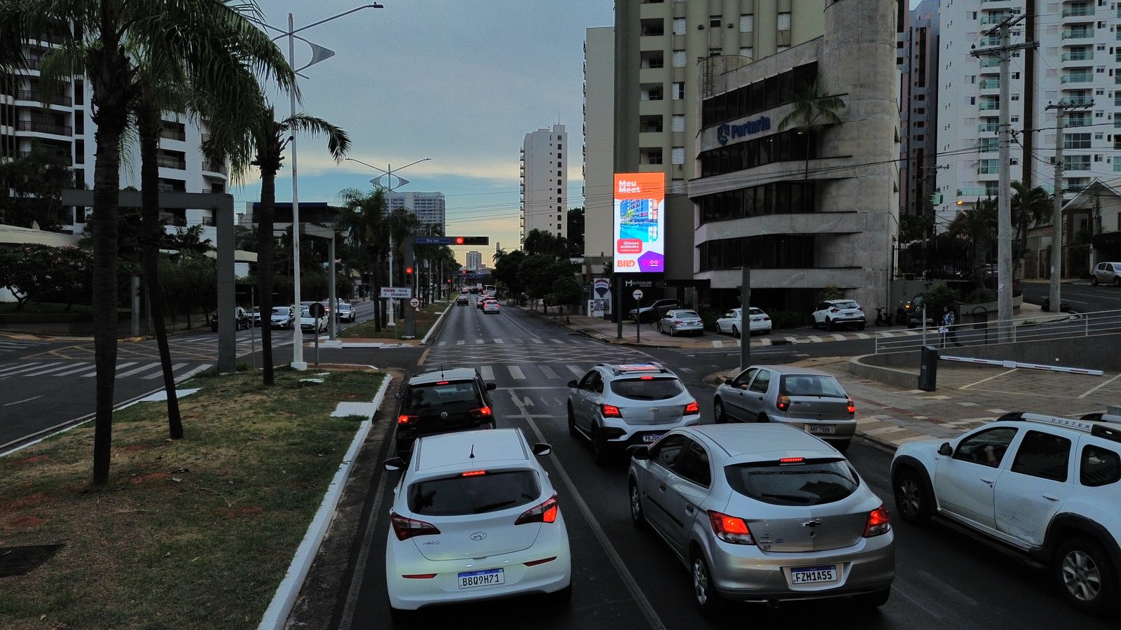 Avenida ao entardecer com painel digital
